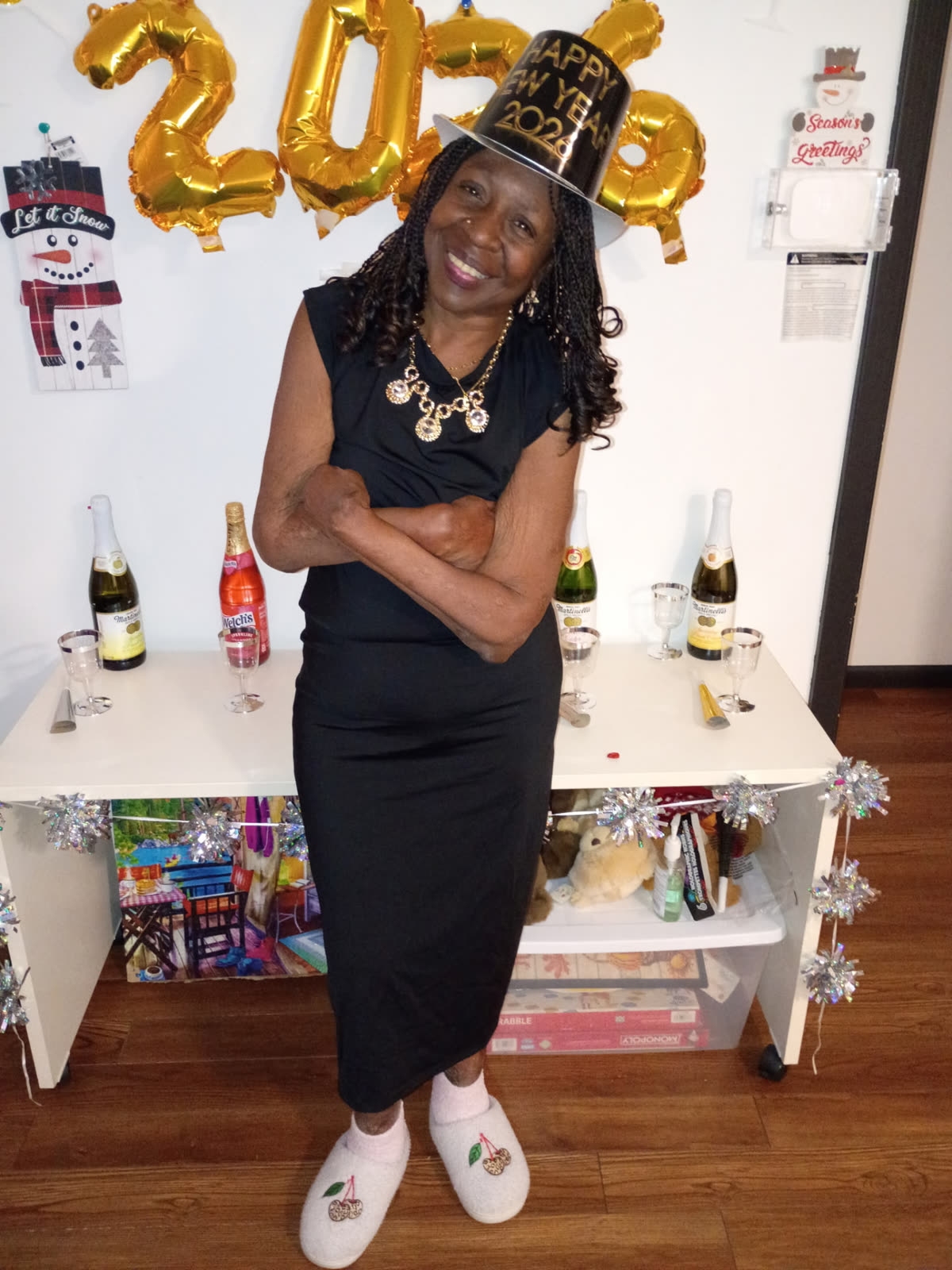 A resident dressed up in a New Year's hat in front of 2026 balloons