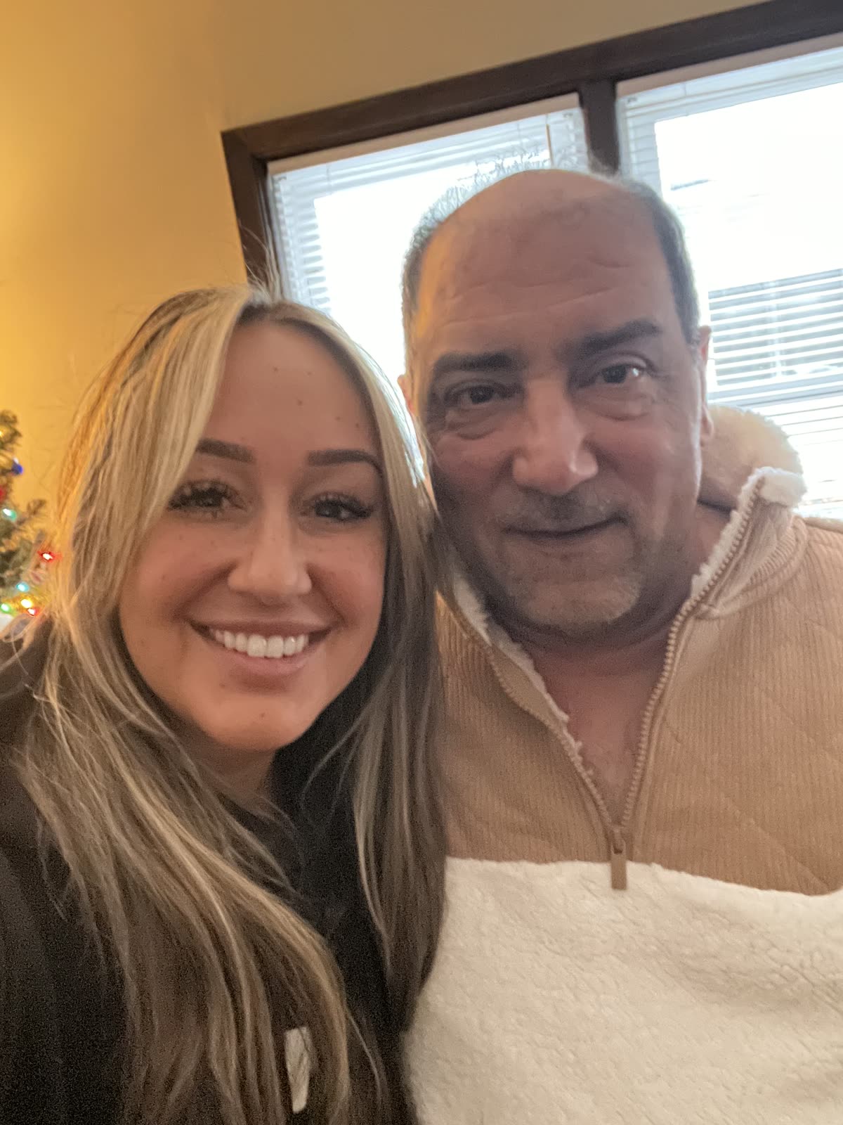A daughter taking a selfie with her father in the living room